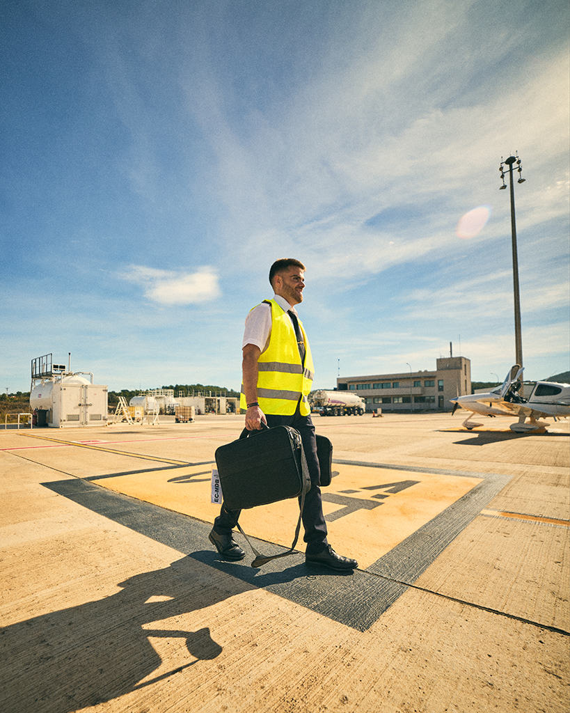 Piloto caminando por la pista de aterrizaje con luz de atardecer, fotografía de estilo lifestyle realizada por fotógrafo para agencias de publicidad en Valencia.