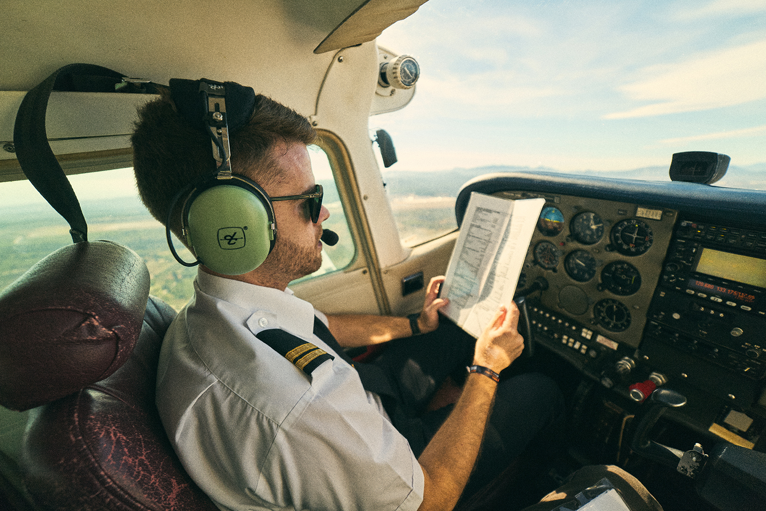 Detalle de piloto ajustando controles en el tablero de avión, fotografía profesional para campañas publicitarias y bancos de imagen